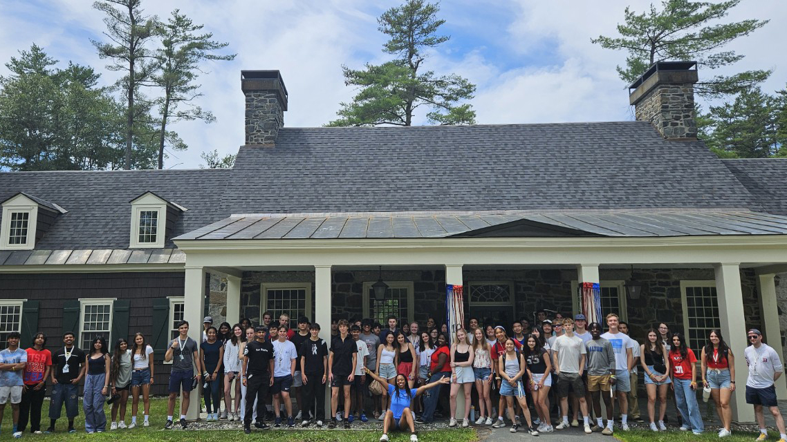 Precollege participants posing in front of a building after a hike